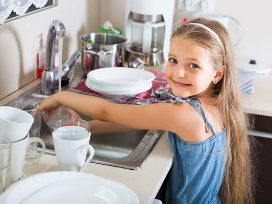 kids cleaning up the kitchen by washing dishes