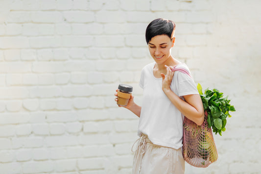woman reducing her waste by using ways on how to reduce waste like using a reusable coffee mug