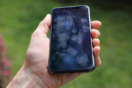 man holding dirty phone looking up The Ultimate Guide On How To Clean Your Phone