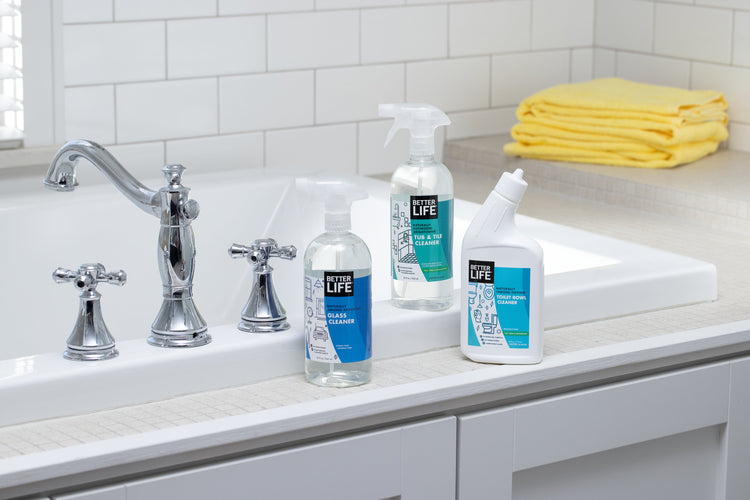 A bathroom sink with several Better Life cleaning products on it.